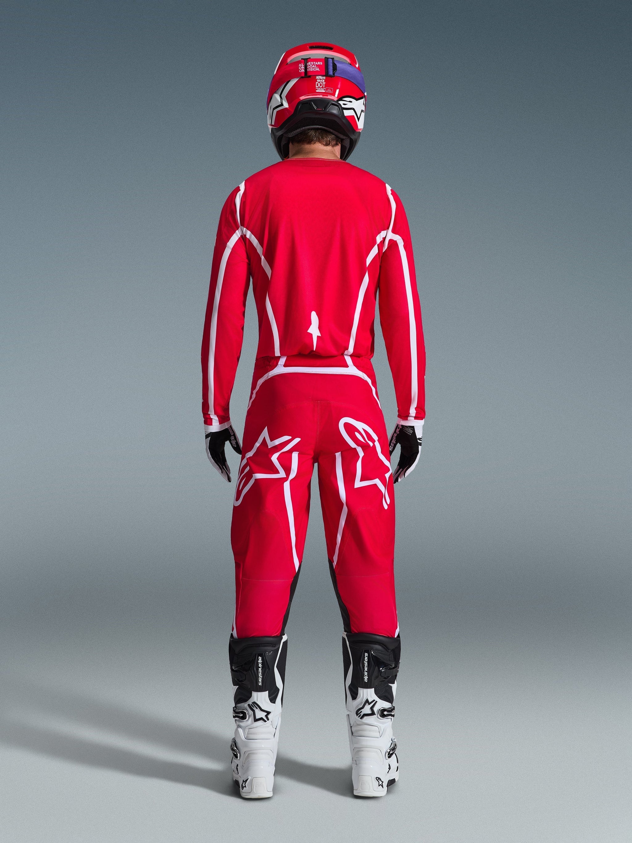 Alpinestars 2026 Fluid Apex Pants, Motocross Pants, Red and White, rear view worn with matching jersey, red helmet, and white and black boots, featuring large white Astar logos on the legs, coordinated outfit for off-road racing