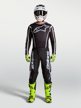 Alpinestars Fluid Apex V2 Pants in Black and Silver, part of a full Men's Motocross gear set with neon yellow boots, helmet, and performance racing jersey.