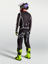 Alpinestars Men's Fluid Apex V2 Motocross Pants in Black and Silver, shown from behind with matching jersey and neon boots.