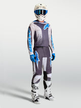 Alpinestars Fluid Drag Pants and gear set, gray and blue motocross apparel with an ergonomic 3D design for performance.