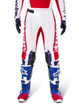 Limited Edition Techstar Fortitude Pants, Motocross Pants, Bright Red White and Blue, worn with matching gear including blue protective boots and gloves, featuring white chassis with red graphics, black leather knee panels, and laser-cut perforations, professional off-road racing apparel