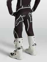 Alpinestars Youth Fluid Apex V2 Pants, Motocross Racing Gear, Youth, Black and Silver, Rear view with white boots.