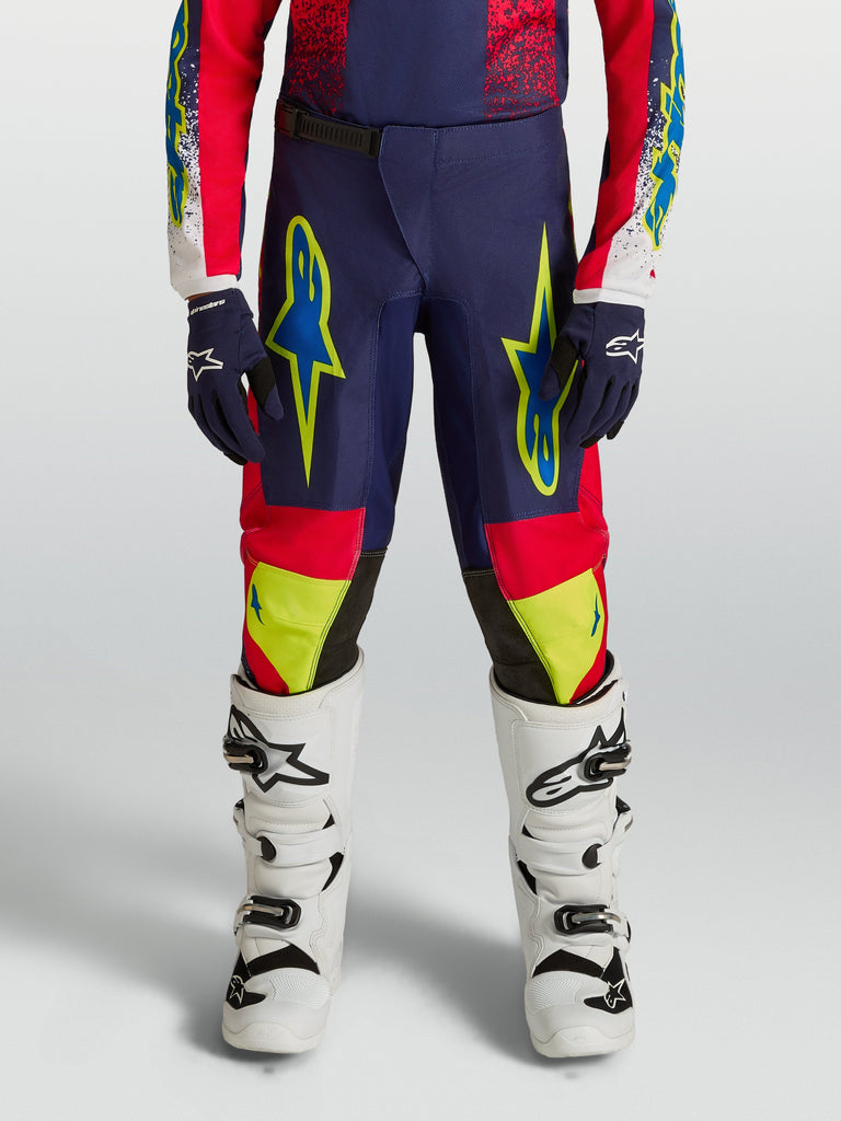 Alpinestars Youth Fluid Drag Pants for Motocross Racing, Blue Navy and Fire Red with Neon Yellow Graphics.