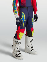 Alpinestars Youth Fluid Drag Pants, navy blue and red motocross racing gear with neon accents and white performance boots.