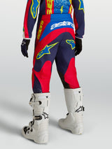 Alpinestars Youth Fluid Drag Pants, navy blue and fire red textile motocross pants, rear view with white boots.