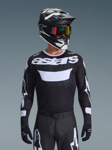 Alpinestars 2026 Racer Air Riway Jersey, Black and White motocross jersey with 'astars' branding, worn by a rider with matching black helmet, goggles, and pants, featuring breathable mesh panels for off-road racing.