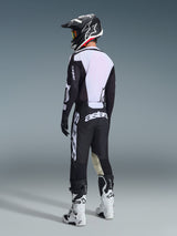 Motocross rider from a rear view wearing the 2026 Racer Air Riway Jersey in Black and White, showcasing the large white mesh back panel for airflow, paired with black pants, black and white helmet, and white racing boots, complete professional gear for off-road performance.