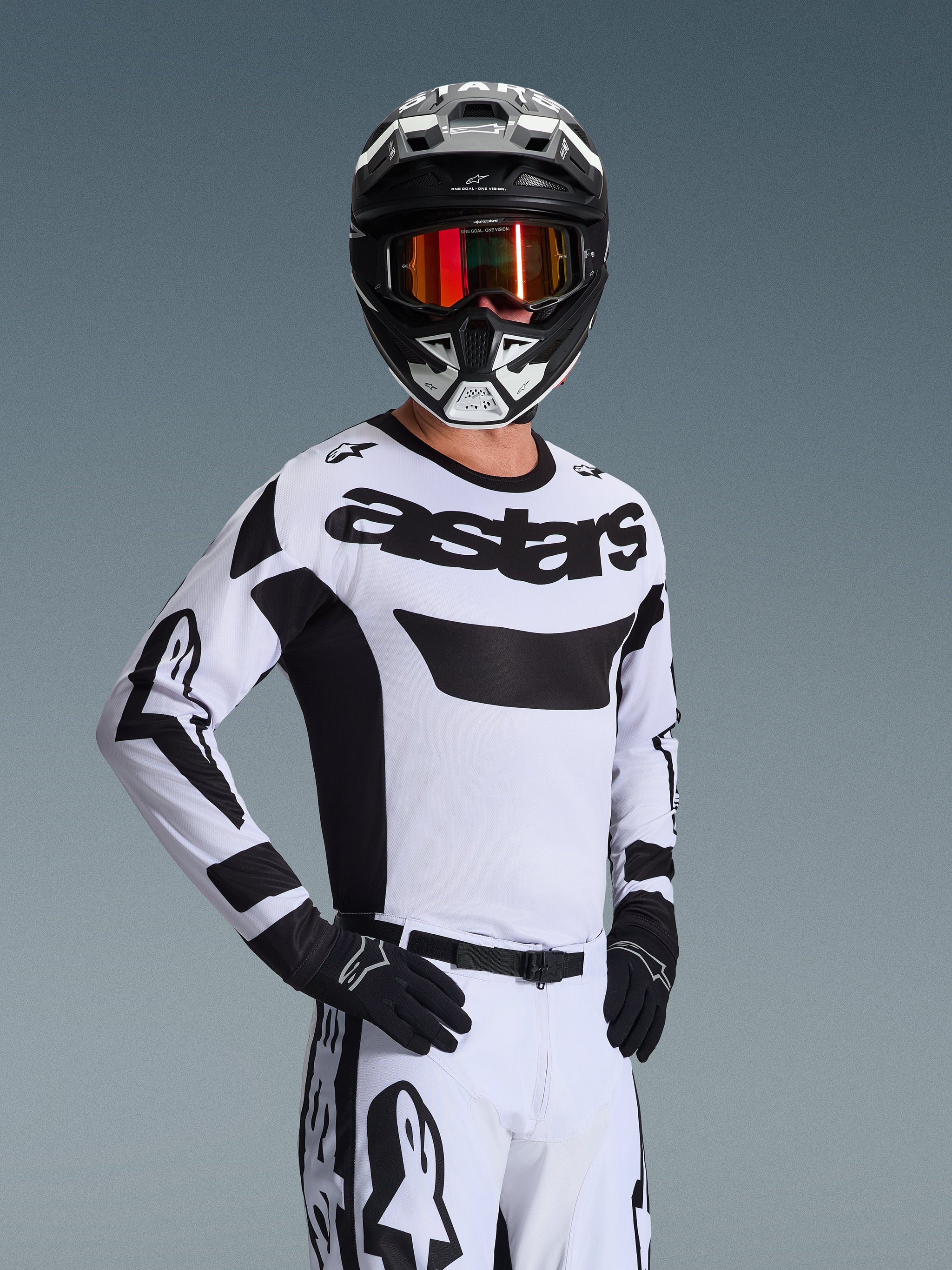 Alpinestars 2026 Racer Riway Jersey, Motocross Jersey, White and Black, featuring bold 'astars' logo on chest, worn with matching white pants and black gloves, black and white helmet with red reflective goggles, professional off-road racing gear