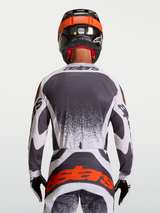 Alpinestars Techstar Swan Jersey in Gray and White, back view of male motocross rider with laser-cut ventilation.