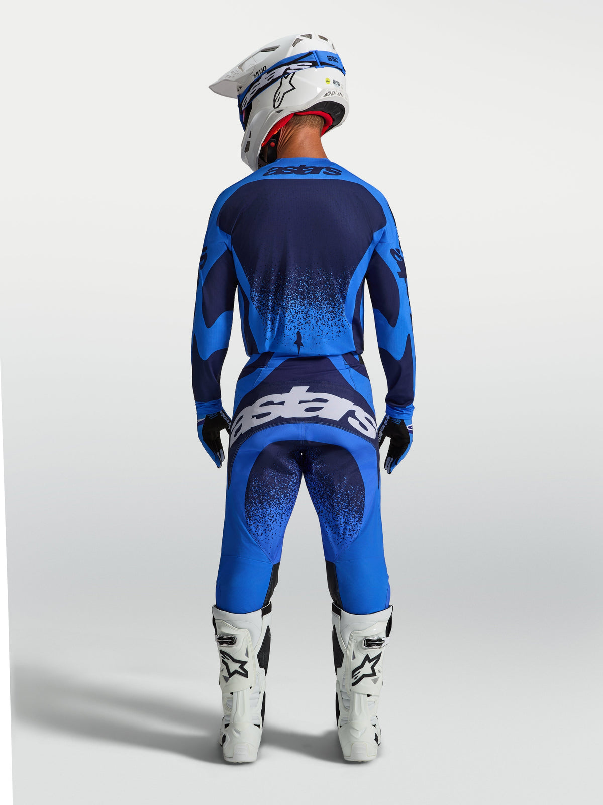 Alpinestars Techstar Swan Jersey and 2027 Gear Set, blue and navy men's motocross outfit, back view with white boots.