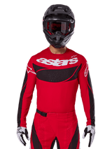Alpinestars 2025 Techstar Dreem Jersey, Motocross Gear, Bright Red and Black, featuring a white 'astars' logo and black ventilated chest panel, worn with matching pants, black helmet, and white and black gloves, designed for professional off-road racing