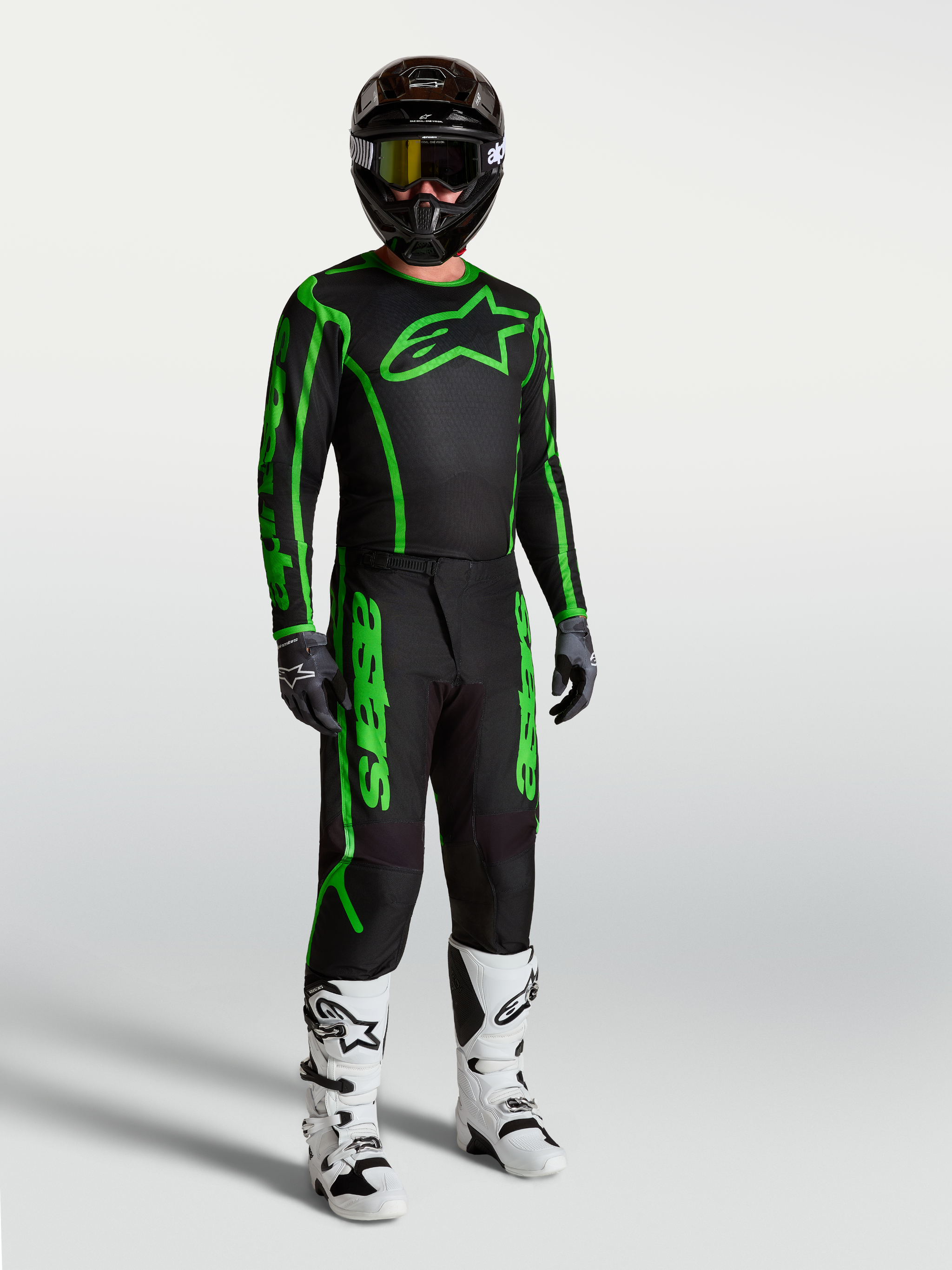 Alpinestars Fluid Apex V2 Jersey, Men's Motocross Gear, Black and Green Fluo, shown on-model with matching pants and boots.