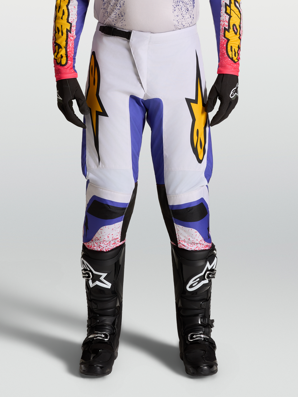 Alpinestars Fluid Drag Pants, Motocross Racing Pants for Men, Light Lilac and Iris Blue with Gold graphic star accents.