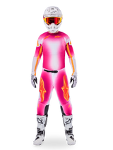 Motocross rider wearing complete racing gear, Limited Edition Supertech AFD MIG Jersey in Pink Fluo and White, matching pants with orange star accents, white helmet with red goggles, white and black boots, coordinated professional motocross outfit