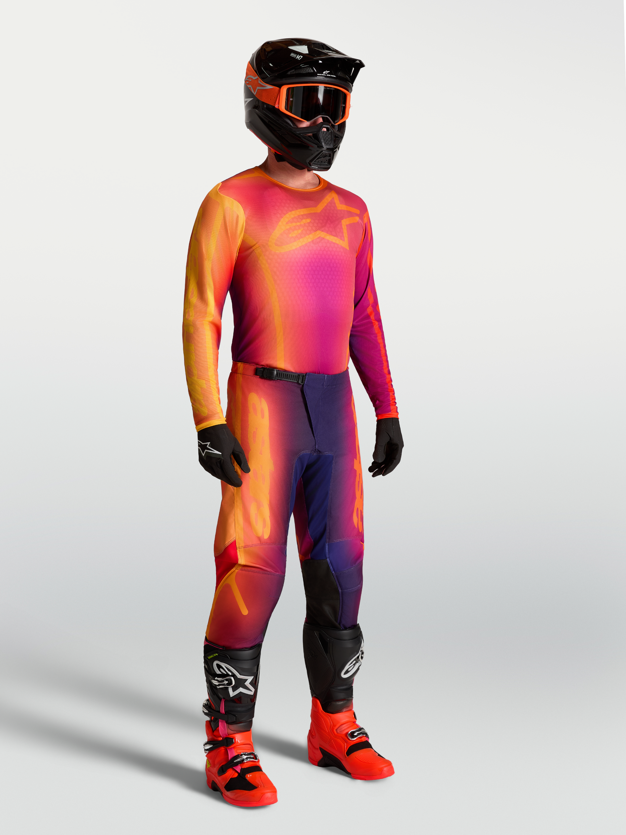 Alpinestars Fluid Kepler Pants and jersey, men's purple and orange motocross gear set with ergonomic fit and off-road boots.