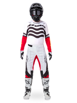 Motocross rider wearing the Alpinestars Limited Edition Techstar Deep Jersey in white, black, and red, featuring wavy chest graphics, paired with matching white and red pants, a black helmet, and white racing boots, full professional off-road gear setup.