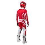 Rear view of a motocross rider wearing the Alpinestars 2024 Fluid Lurv Jersey in Mars Red White, paired with matching red and white pants, white off-road boots, and a red helmet, showing the jersey's back design and Alpinestars branding.