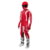 Motocross rider wearing complete racing gear, Alpinestars 2024 Fluid Lurv Jersey in Mars Red and White, matching red pants with white accents, red helmet, red gloves, and white and black boots, coordinated outfit for off-road racing