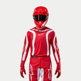 Alpinestars 2024 Fluid Lurv Jersey, Motocross Jersey, Mars Red and White, worn with matching red pants, helmet, and gloves, featuring white graphic accents on the sleeves and bold chest branding, athletic fit for off-road racing