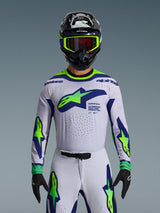 Alpinestars 2026 Supertech Vista Jersey, Motocross Jersey, Light Gray Yellow Fluo and Blue, worn by a rider with matching pants and black helmet, featuring a large chest logo and laser-cut perforations for ventilation, pro-level athletic fit