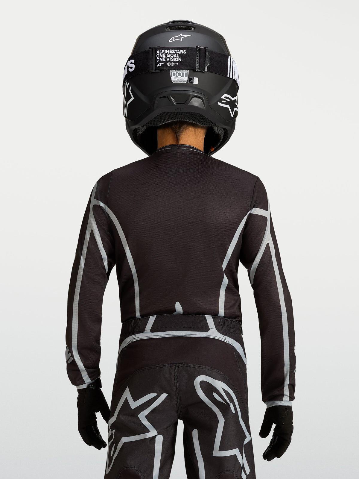 Alpinestars Youth Fluid Apex V2 Jersey, Black and Silver motocross top with ergonomic fit and extended rear coverage.