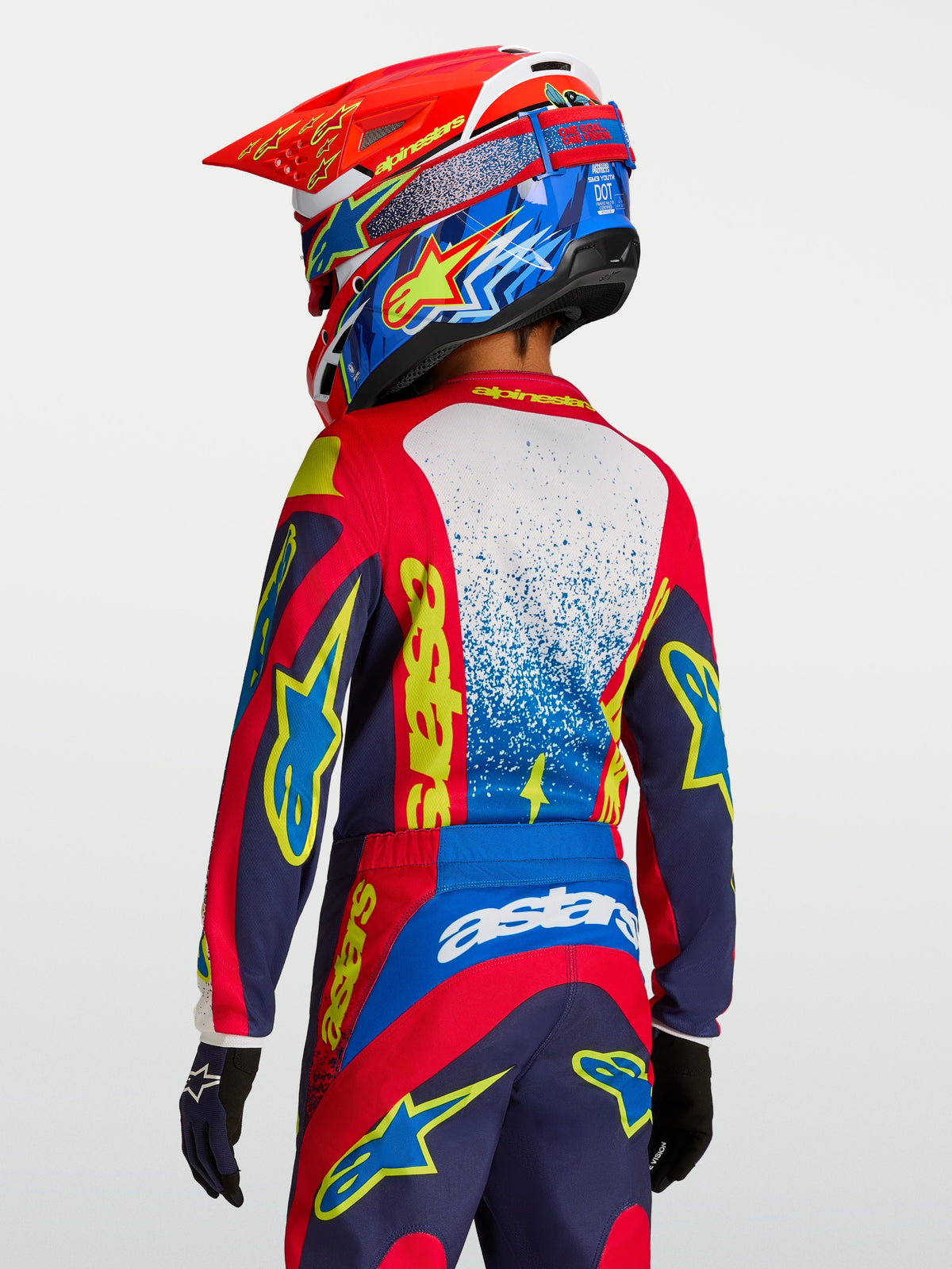 Alpinestars Youth Fluid Drag Jersey, red and navy blue youth motocross jersey with yellow graphics, rear view on rider.