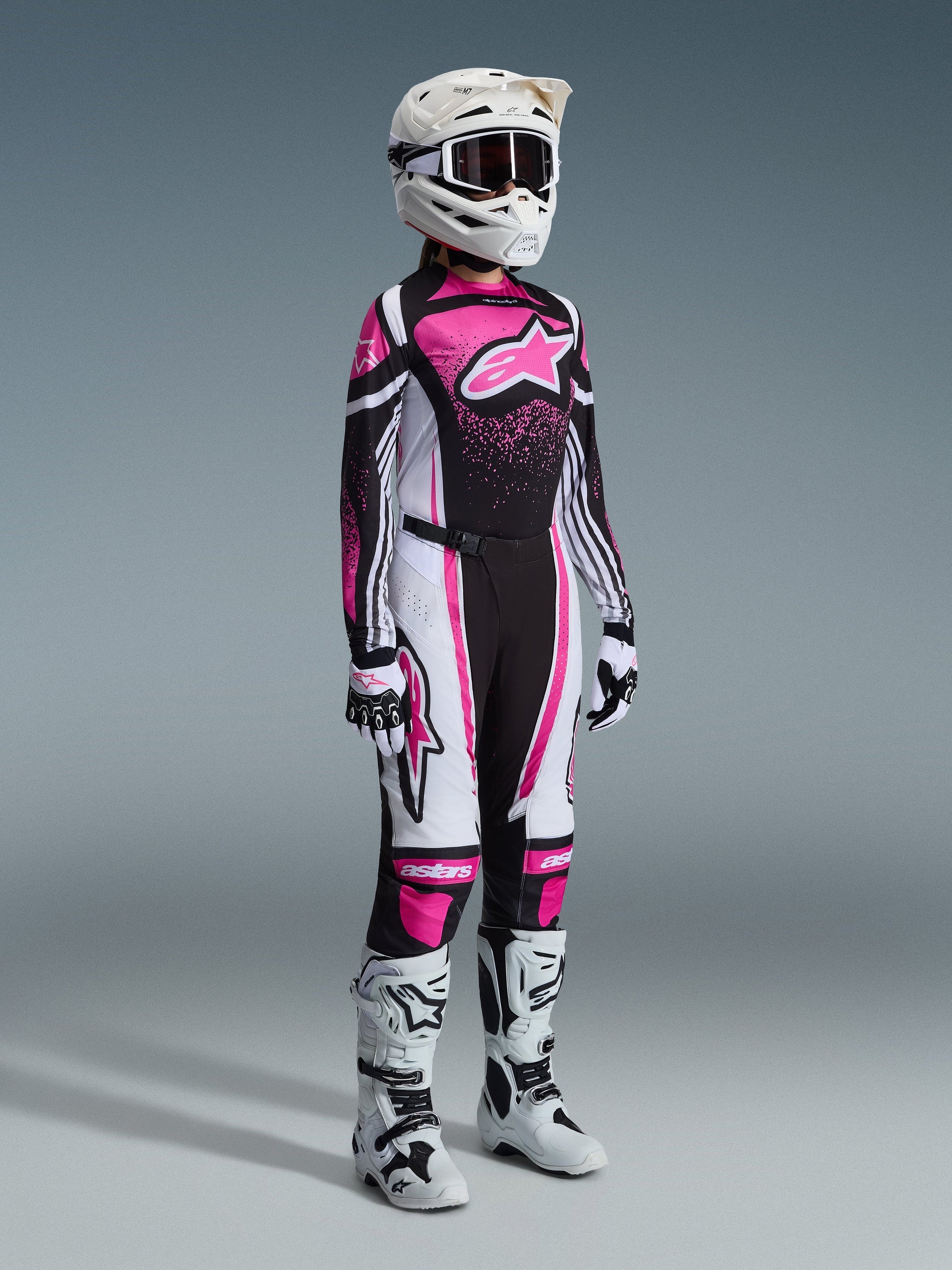 Alpinestars 2026 Stella Techstar Nomur Gear Set, full women's motocross racing gear, vibrant pink black and white jersey with matching pants, white helmet and goggles, white and black boots, professional coordinated motocross outfit