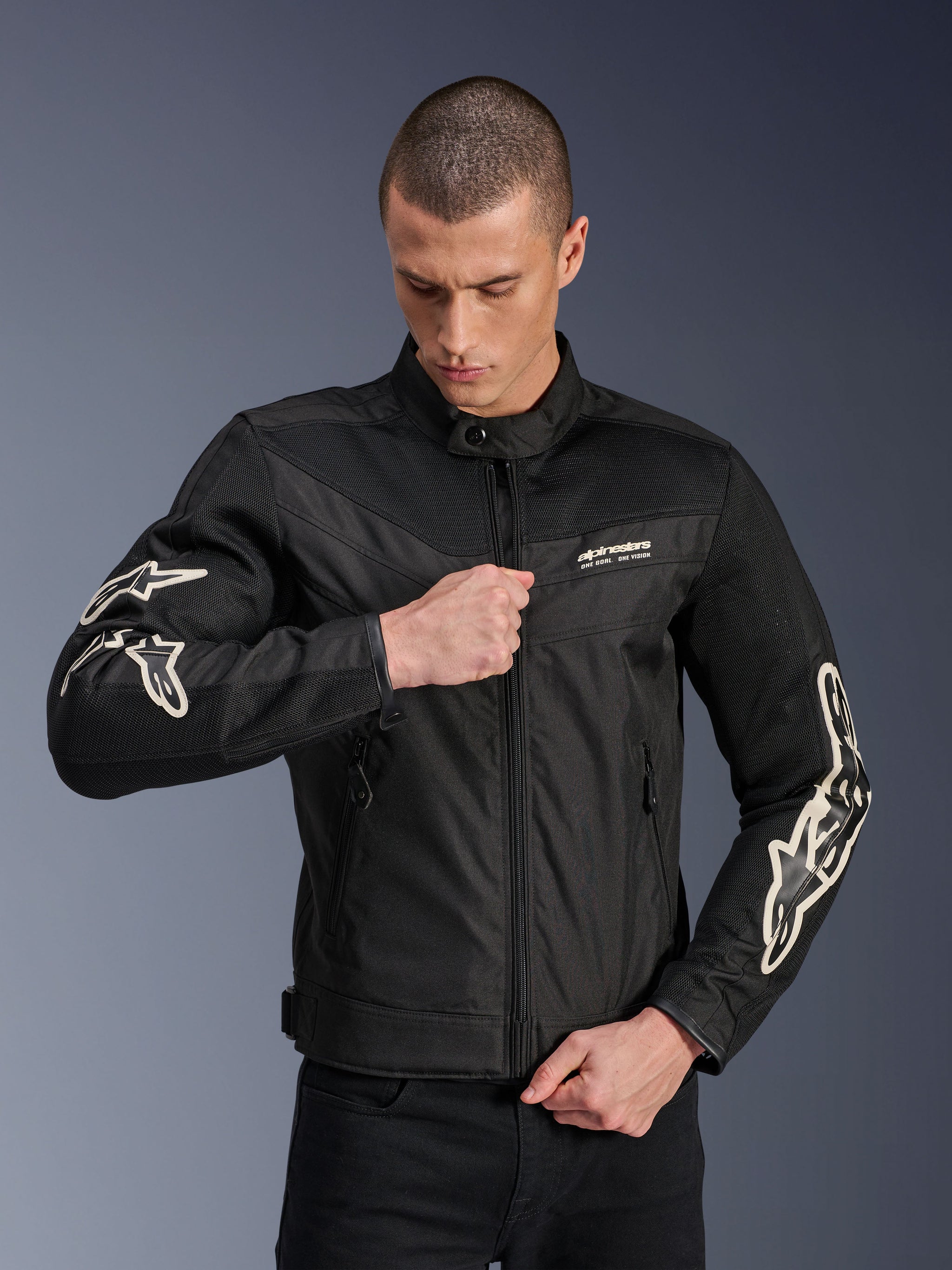 Alpinestars T-Dyno Air Jacket, Black, textile motorcycle jacket with 3D mesh panels and white sleeve logos, worn by a model zipping the front, urban street riding style