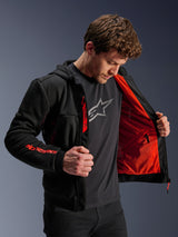 Alpinestars Chrome Air Sport Hoodie in Black and Red Fluo, male model opening the jacket to showcase the bright red mesh lining, Alpinestars branding on the right sleeve and chest zipper, casual urban motorcycle jacket designed for airflow.