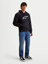 Alpinestars Ageless Hoodie, men's urban motorcycle riding hoodie in black, front view on a model wearing casual denim jeans, featuring a prominent white Astar logo on the chest and internal abrasion reinforcements.