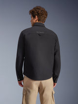 Alpinestars Bryon Water Resistant Overshirt, Black, Rear view worn by model, featuring embroidered branding on the back yoke and utility hanging loop, styled with tan cargo pants, urban motorcycle gear with classic workwear aesthetic
