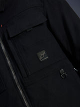 Alpinestars Bryon Water Resistant Overshirt, Black, close-up view of waxed canvas fabric, front zipper, chest cargo pocket with Alpinestars logo patch, and metal D-ring detail