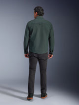 Alpinestars Bryon Water Resistant Overshirt in Dark Emerald, back view on model, paired with dark grey motorcycle pants and black riding shoes, showcasing a classic workwear-inspired design with a slightly longer back for riding coverage.
