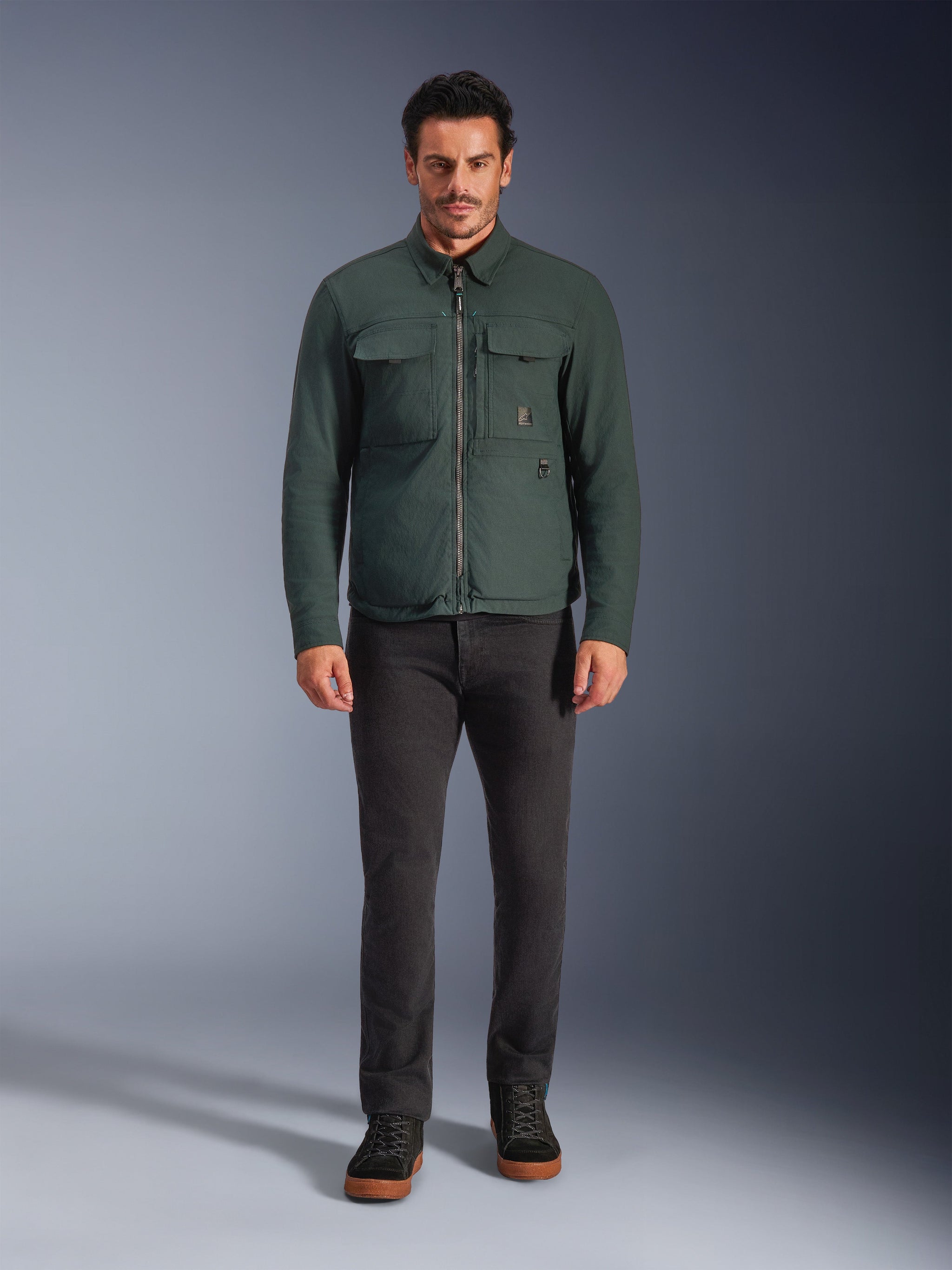 Alpinestars Bryon WR Overshirt, Water-Resistant Motorcycle Jacket, Dark Emerald, worn with black pants and black boots, featuring waxed canvas construction, chest cargo pockets, and a modern urban design.