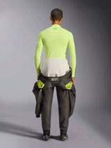 Alpinestars ZX Evo V3 Top, Long Sleeve Base Layer, Yellow Fluo, back view of a driver with a racing suit tied around the waist, vibrant neon yellow flame-resistant top featuring a small black logo on the neck and a slim athletic fit