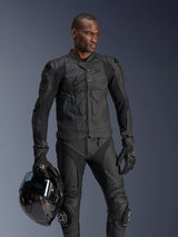 Alpinestars Dusk Airflow Leather Jacket, Black, worn by a male rider with matching leather pants and gloves, holding a black helmet, featuring perforated leather panels and integrated armor for sport motorcycle riding