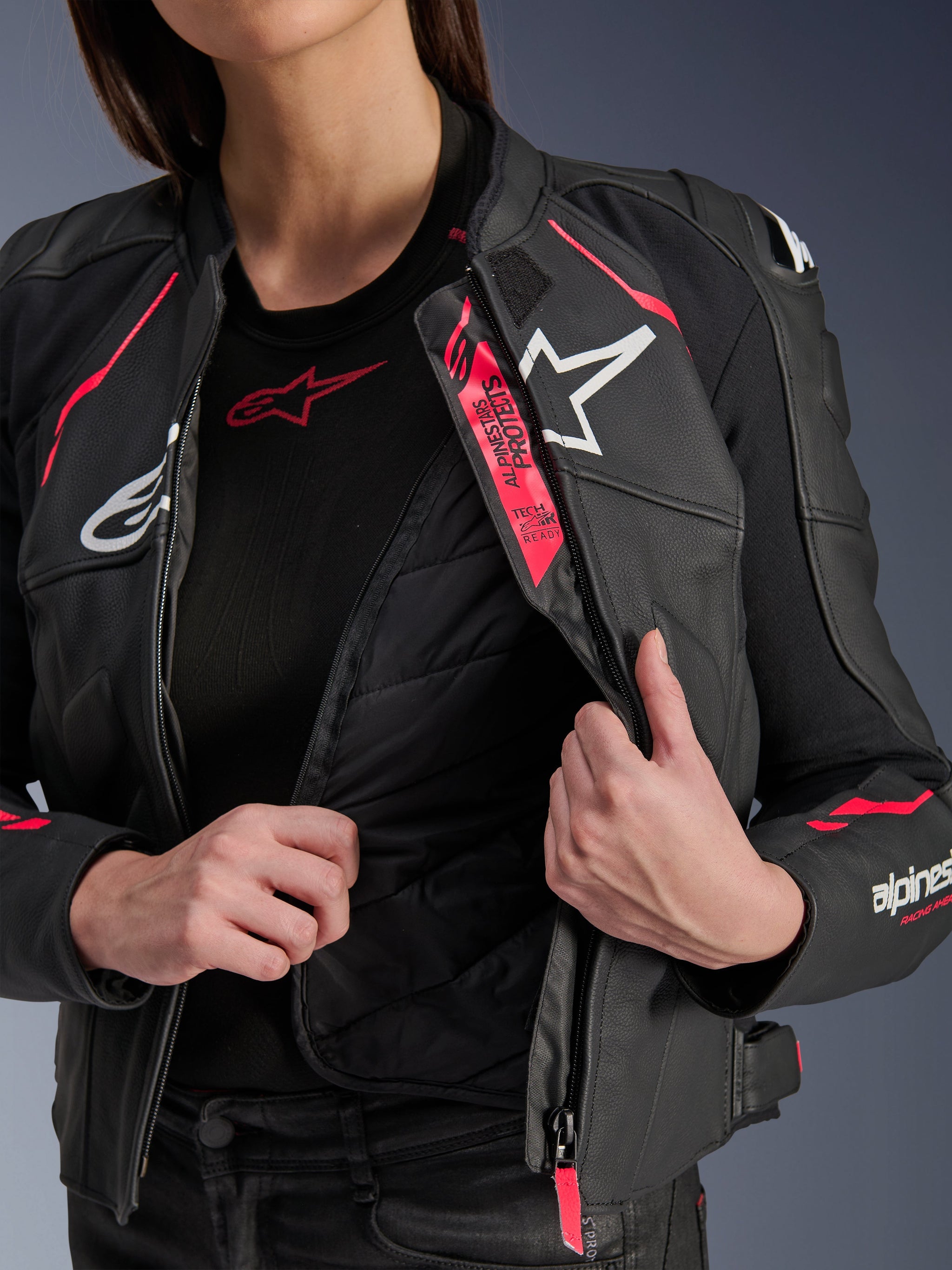 Alpinestars Woman Stella Dusk Leather Jacket, Black Diva Pink and White, leather motorcycle jacket unzipped to display the internal quilted thermal liner and Tech-Air Ready branding, featuring white logos and vibrant pink accents.