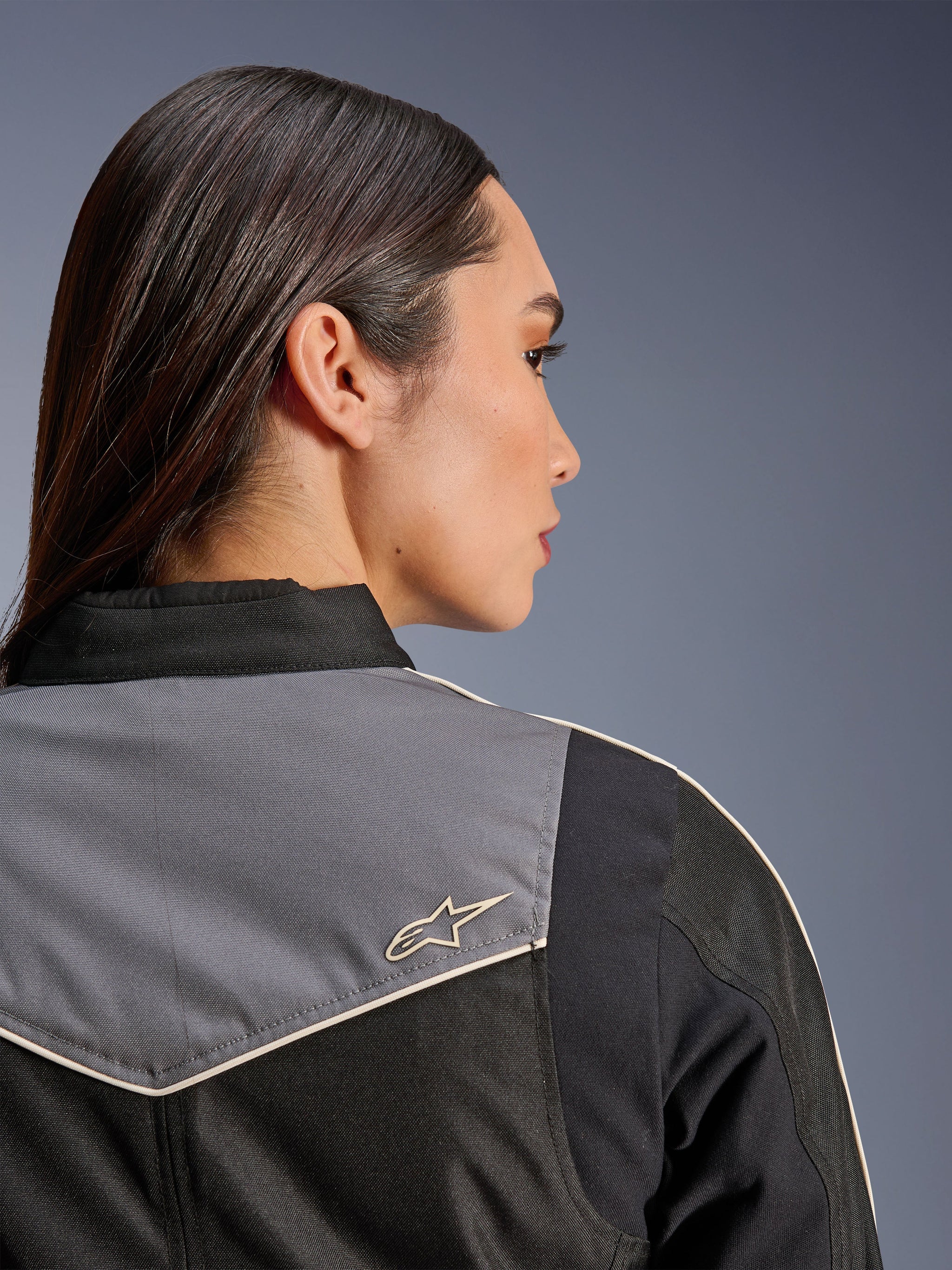 Alpinestars Stella T-Dyno WR Jacket, Women's Motorcycle Jacket, Black Dark Gray and Ecru, close-up back view of shoulder and yoke featuring gray panel with ecru star logo, vintage-inspired riding gear