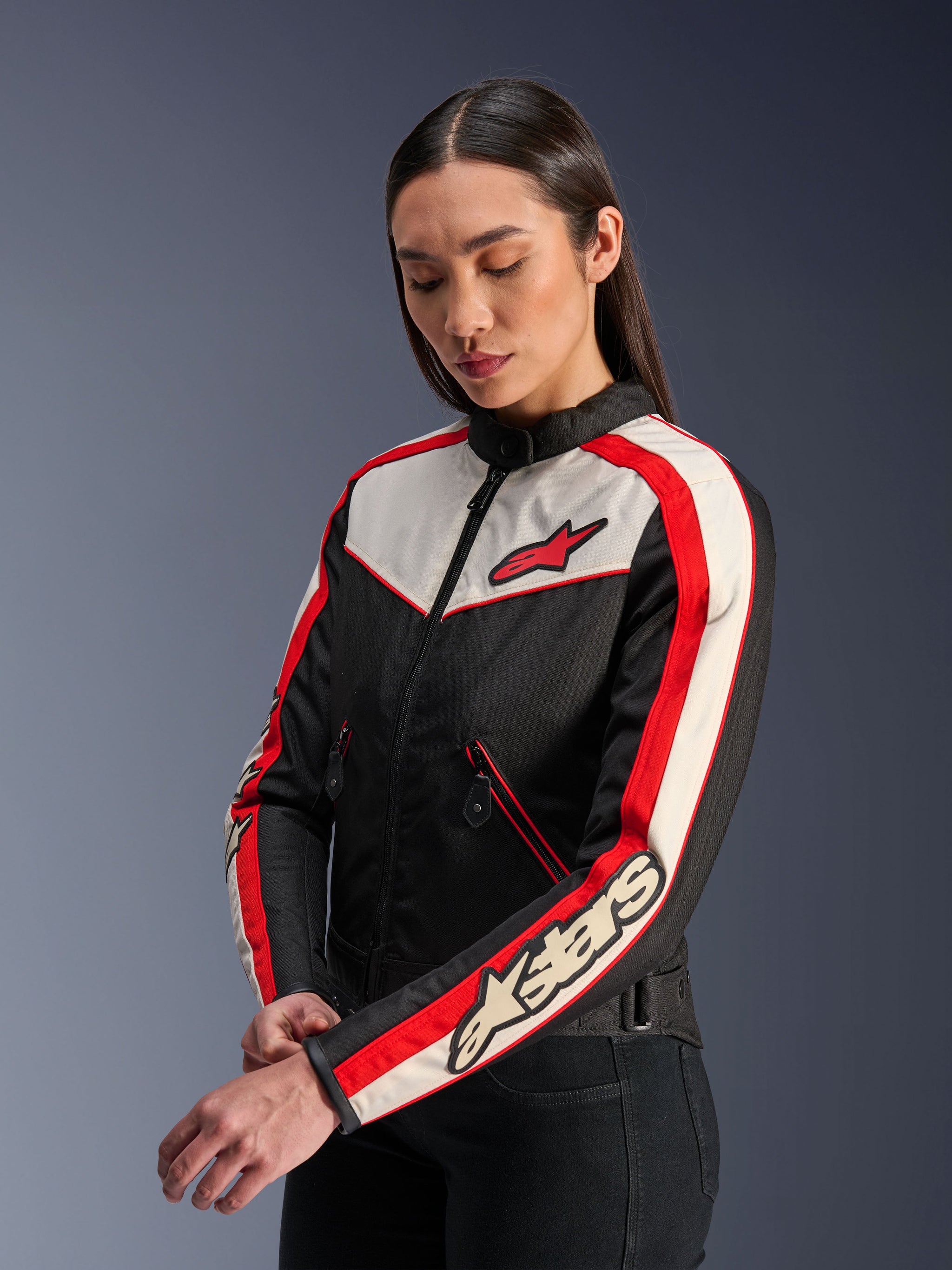 Alpinestars Stella T-Dyno WR Jacket, Women's Textile Motorcycle Jacket, Black Ecru and Bright Red, vintage-inspired design with red Alpinestars logo on the chest and branding on the sleeve, worn by a model in a studio setting.