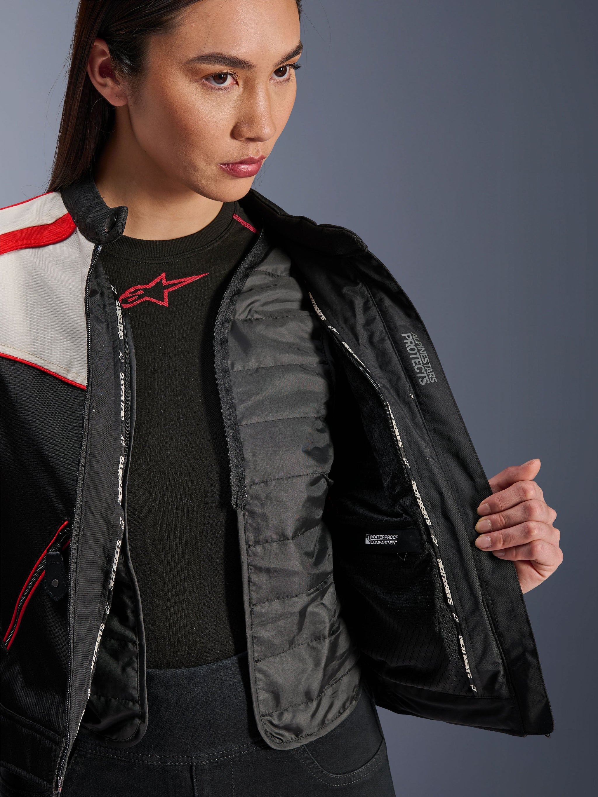 Alpinestars Stella T-Dyno WR Jacket, Women's Motorcycle Jacket, Black Ecru and Bright Red, close-up interior view showing the detachable quilted thermal vest, waterproof inner compartment, and 'ALPINESTARS PROTECTS' branding.