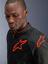 Alpinestars Viper Air V4 Jacket, Black and Red Fluo, worn by a male model, close-up view showing mesh textile panels and bright fluorescent red Alpinestars logos on the chest and shoulder, sporty motorcycle road gear