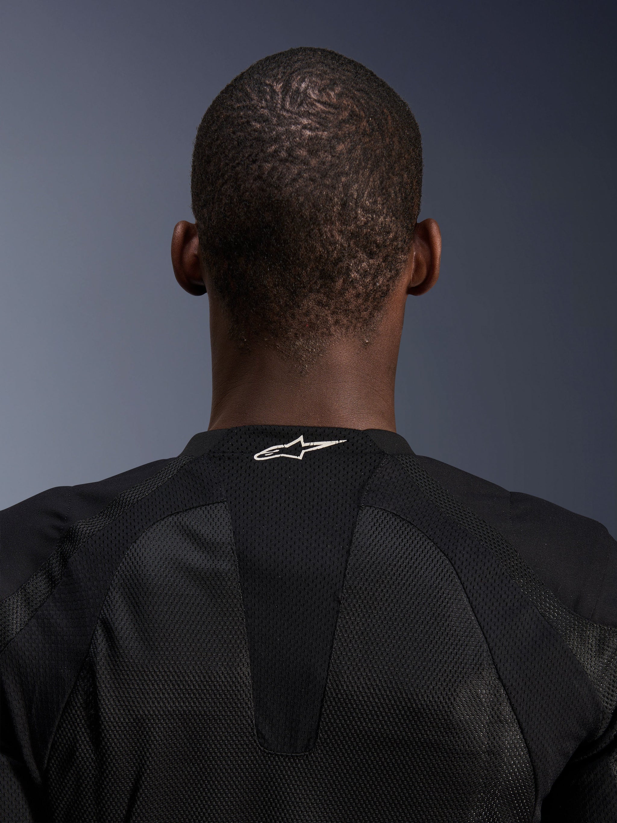 Alpinestars Troop-Air Jacket, black tech mesh motorcycle jacket detail showing white logo on back neck.