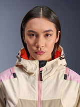 Close-up of a female model wearing the Alpinestars Molly Air Jacket in Sand Pink Almond, featuring a high collar and hood with bright orange lining, pink front zipper, ripstop fabric with laser-perforated chest for ventilation, urban motorcycle protective gear