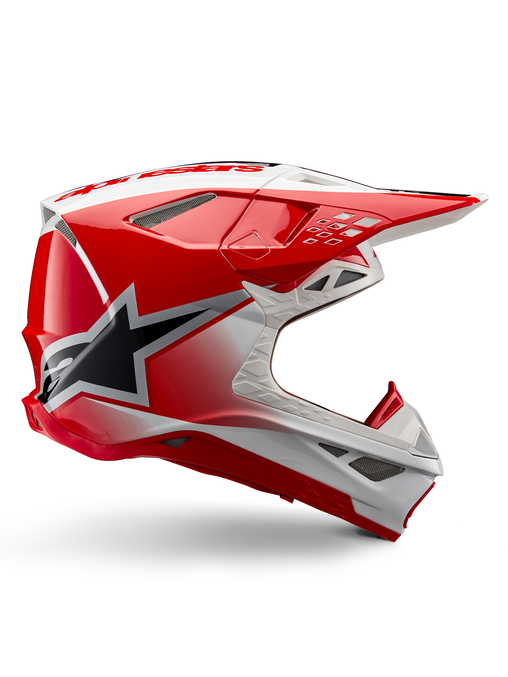 Alpinestars Supertech M10 Unite Helmet, Motocross Racing Helmet, Red and White Glossy, featuring a side view with angular geometric patterns, black star graphic, multiple mesh air vents, and aerodynamic design for off-road racing