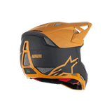 Alpinestars Missile Tech Racer Helmet, Full-Face MTB Helmet, Black and Dark Gold Matt, rear side view featuring mesh ventilation ports, aerodynamic visor, and Alpinestars Protects branding on the back, professional downhill cycling protection.