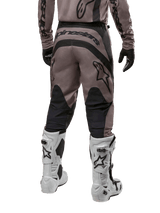 Alpinestars 2024 Fluid Lurv Pants, Motocross Pants, Mud Black, back view showing large black Alpinestars logo on the seat and black calf panels, worn with white and black motocross boots and matching jersey.