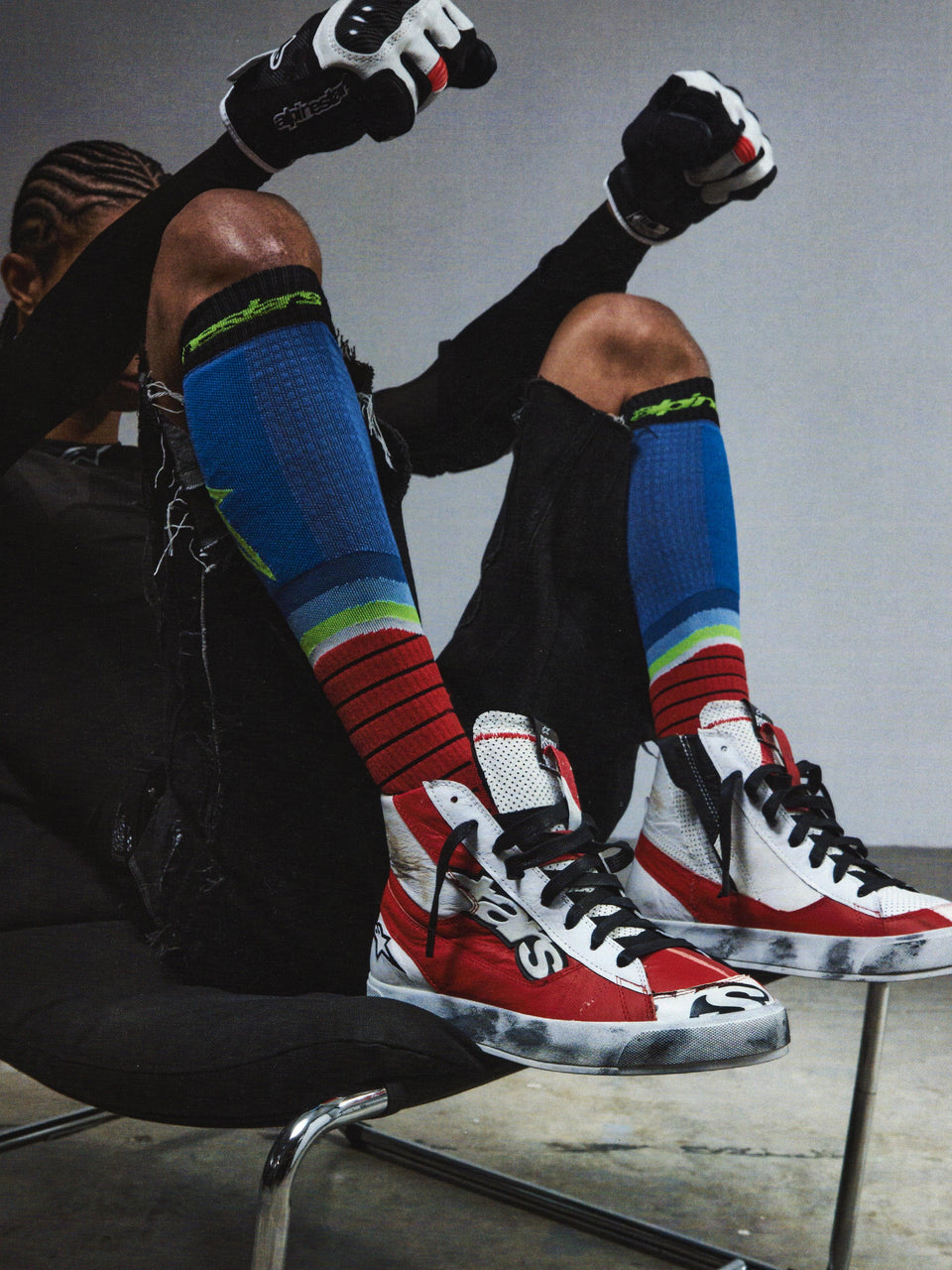 Alpinestars RSRV Legacy Shoe, Red White and Black High-Top Sneakers, Premium Lifestyle Footwear, Worn Texture with Black Scuffs, Person Wearing Colorful Striped Socks and Black Gloves
