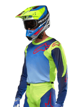 Alpinestars 2024 Racer Hoen Jersey, Motocross Jersey, Yellow Fluo and Blue Night Navy with red logos, worn with a matching yellow, blue, and red helmet and blue gloves, vibrant gear for off-road racing