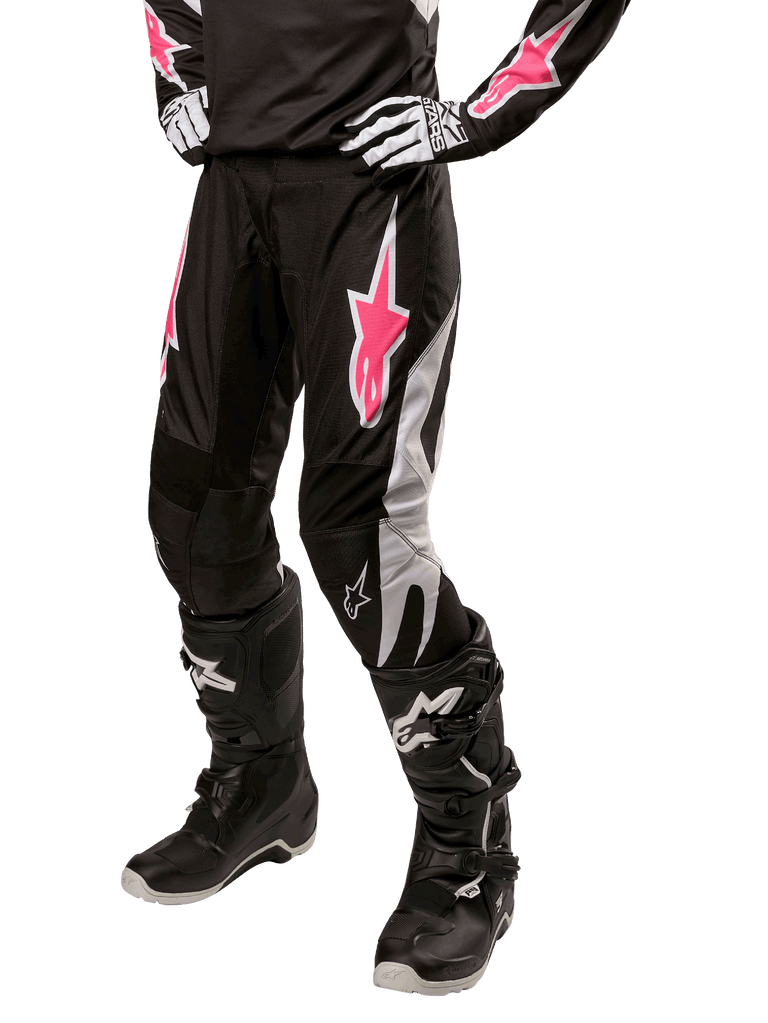 Alpinestars Women Stella 2024 Fluid Pant, Motocross Pants, Black and White with Pink accents, worn with matching protective gear including boots and gloves, durable flexible fabric for off-road riding