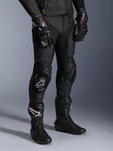 Missile V3 Leather Pants, Black Motorcycle Racing Pants, worn with matching GP Pro gloves and technical racing boots, premium leather construction with white logo knee sliders, professional racing aesthetic for track and road use